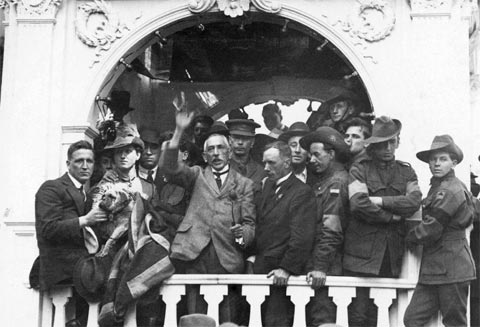 Prime Minister Billy Hughes is seen delivering a speech at the ‘Temple of Peace’ which was designed by the same architects as the Commonwealth Bank, Herwald and John Kirkpatrick. The occasion was the Prime Minister's first visit to Sydney in more than 16 months, having been in England and the Versailles Peace Conference. Billy Hughes was carried from Town Hall to Martin Place on a chair that was fixed to two slender poles. Someone in the crowd handed him a bulldog, which may be seen in the photograph. Once at Martin Place, Hughes rallied the crowds explaining the use of the peace loans and their importance.