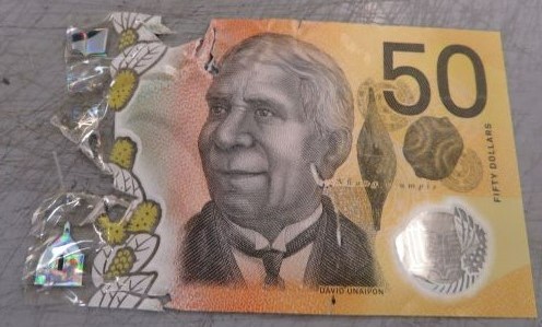 Half a $50 banknote with a tear down the centre.